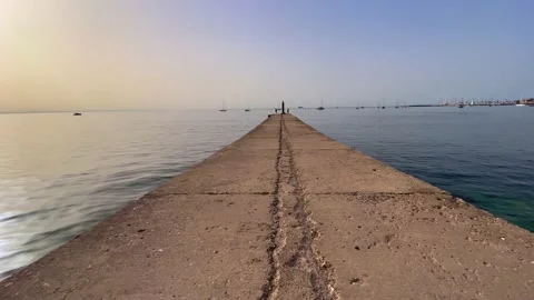 Walking in a jetty in front of the sea in a summer day Stock Footage 218315479
