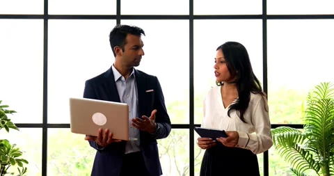 Walking with laptop inside office, Indian business professionals discuss project Stock Footage 342593434