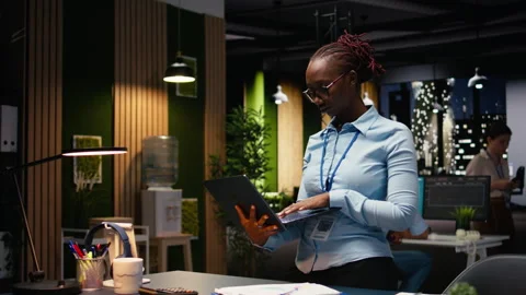 Walking with laptop, office professional evaluating performance metrics Stock Footage 334040142