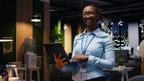 Walking with laptop, office professional evaluating performance metrics Stock Photos
