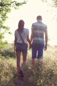 Walking loving couple at sunset Stock Photos