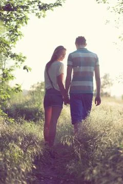 Walking loving couple at sunset Stock Photos