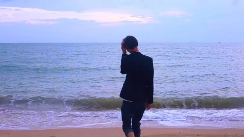 Walking man on the beach looking a head to futher Stock Footage 94018189