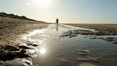 Walking man in the sunset on the beach Stockbeeldmateriaal 255929507
