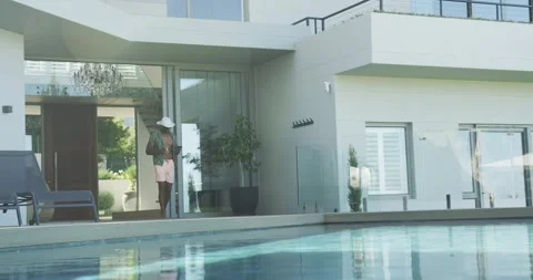 Walking man wearing white hat, shoulder bag, adjusting hat on pool deck near Stock Footage 335131762