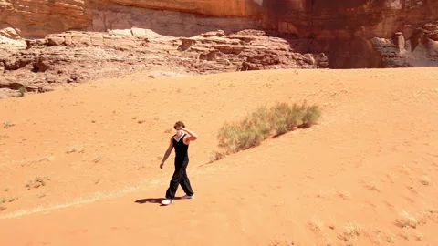 Walking in Marsian desert, bubble camp in background, Wadi Rum, Jordan - 04 Video stock 259361726