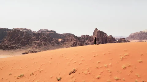 Walking in Marsian desert, bubble camp in background, Wadi Rum, Jordan - 01 Stock Footage 259376191