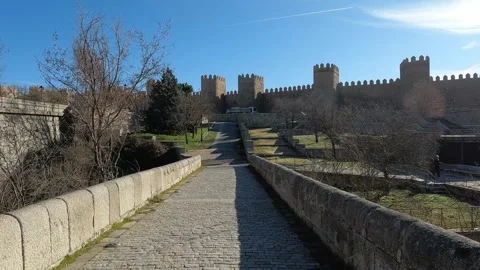 Walking on the medieval bridge of Avila with the crenelated city wall, Spain Stock Footage 345216228