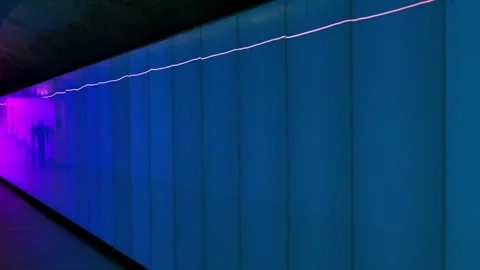 Walking in a Modern Changing Blue and Pink Illuminated Underground Tunnel Vídeos de archivo 264576363