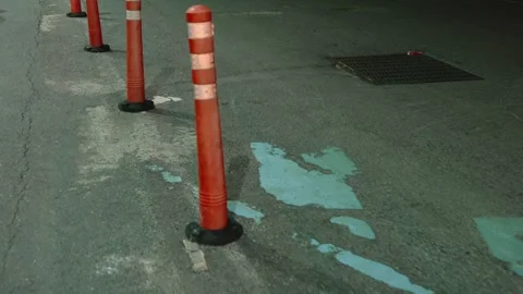 Walking motion along orange reflective traffic delineator poles placed on a dark Vídeos de archivo 310164176