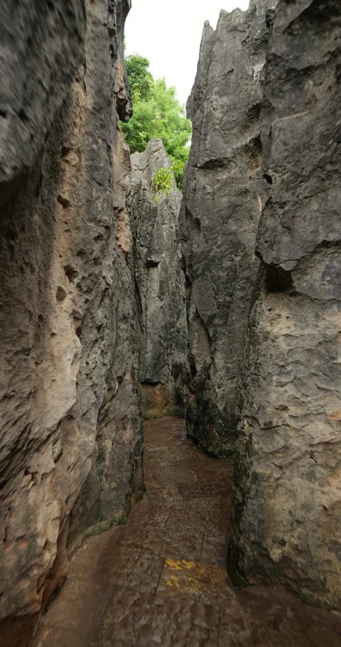 Walking at narrow path in imressive maze of Shilin Stone Forest, vertical shot Vidéo 329595987