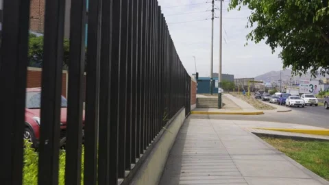 Walking next to some black bars of a condo on the street Stock Footage 150289041