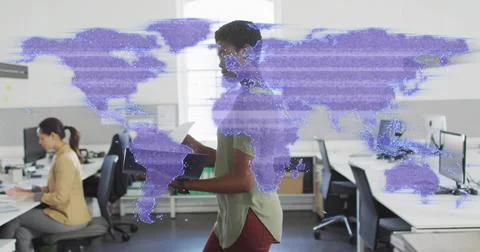 Walking office worker in green top, reading document in open office with purple Stock Photos