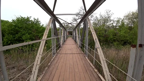Walking on old bridge across a river in a park. POV shot. Stock Footage 107607822