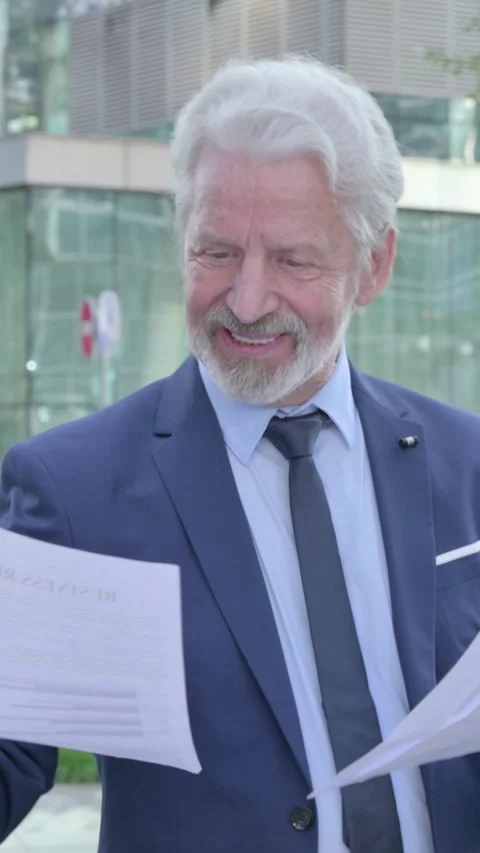 Walking Old Businessman Happy while Reading Documents in Street, Vertical Video Vídeo Stock 339671348