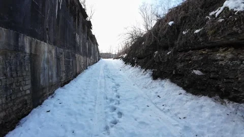 Walking-out-of-abandoned-bunker-to-snowy-road-002 Stock Footage 330763040