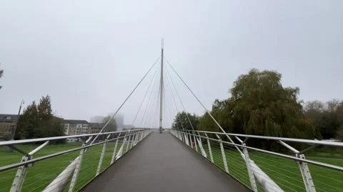 Walking over a modern bridge over Thames River in England Stock Footage 288487976