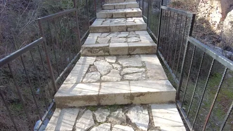 Walking over the stone bridge over the stream. Stock Footage 230060622