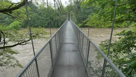 Walking over swollen river Stock Footage 130375129