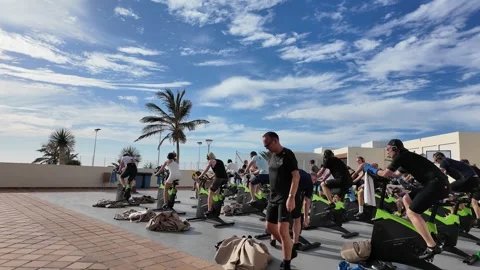 Walking overview of spin bike class as participants cycle following Stock Footage 345312661