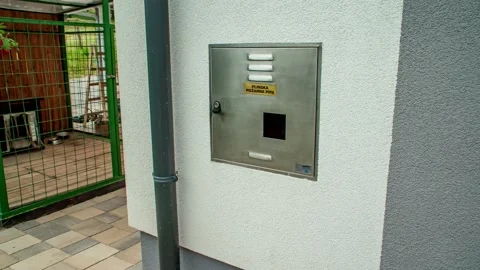 A walking pan shot of an electric control box mounted on a gray wall Stock Footage 150439701