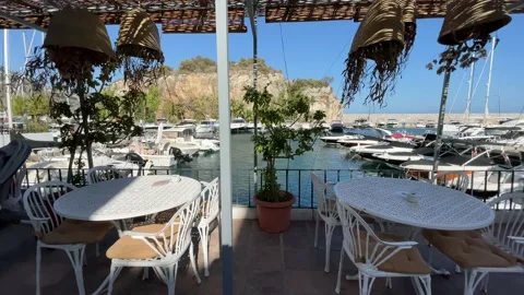 Walking past restaurant tables in front of luxury motor yachts at Marina del Stock Footage 163619790