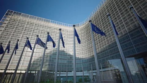 Walking past a Row of EU Flags beside Berlaymont building Brussels Belgium 動画素材 340558765