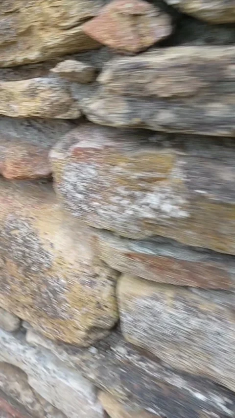 Walking past a rustic stone wall close up vertical video 스톡 동영상 339269961