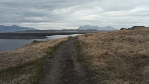 Walking on a patch leading towards the big stone on the black beach in Stock Footage 108583521