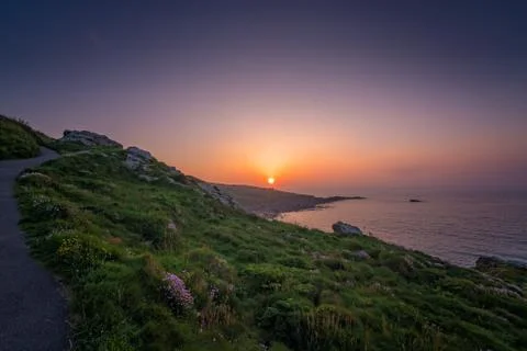 Walking path along the Cornish coast at sunset Stock Photos