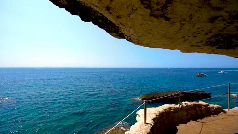 Walking in a path craved in the rocks in the coast by the sea Stock Footage 169701891