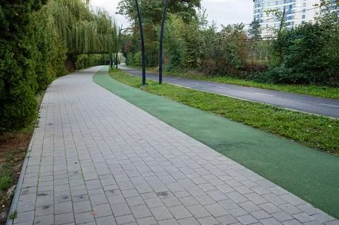 Walking path lined with trees offers a peaceful retreat in a modern urban s.. 스톡 사진