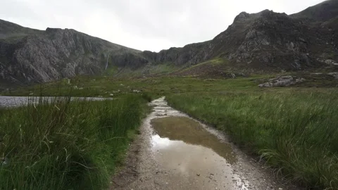 Walking path in the mountains with a big puddle of water Vídeo Stock 138788541