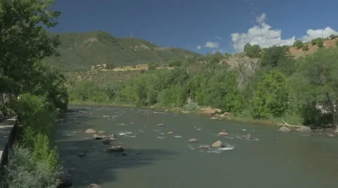 Walking path next to a running river in mountain town Stock Footage 57397161
