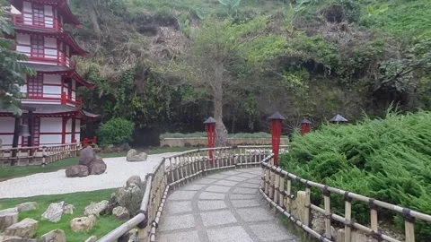 Walking path in a scenic garden with stone walkway and red pillars Stock Footage 345654372