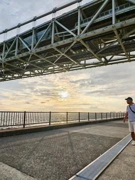 Walking Path Under a Waterfront Bridge During Sunset Stock Photos