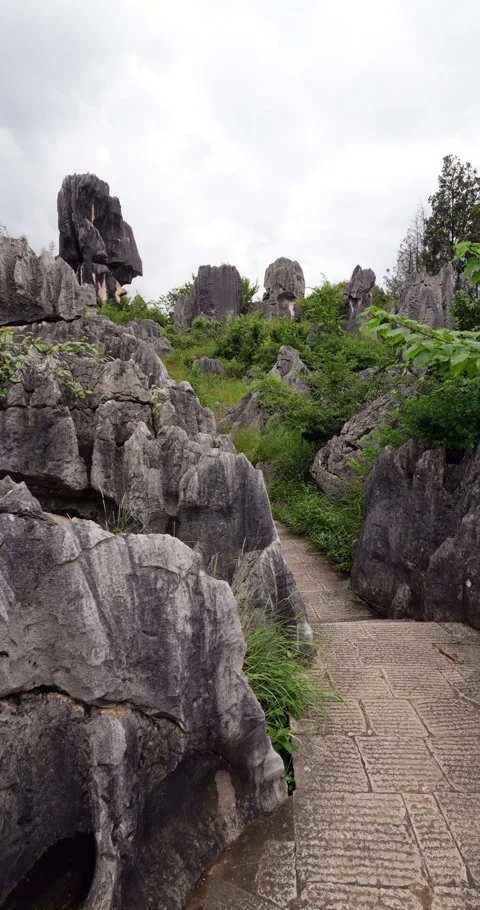 Walking at pathway through Shilin Stone Forest, vertical POV shot Stock Footage 329622733