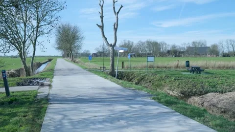 Walking perspective along a country path in rural netherlands on a sunny day Видео 331188936