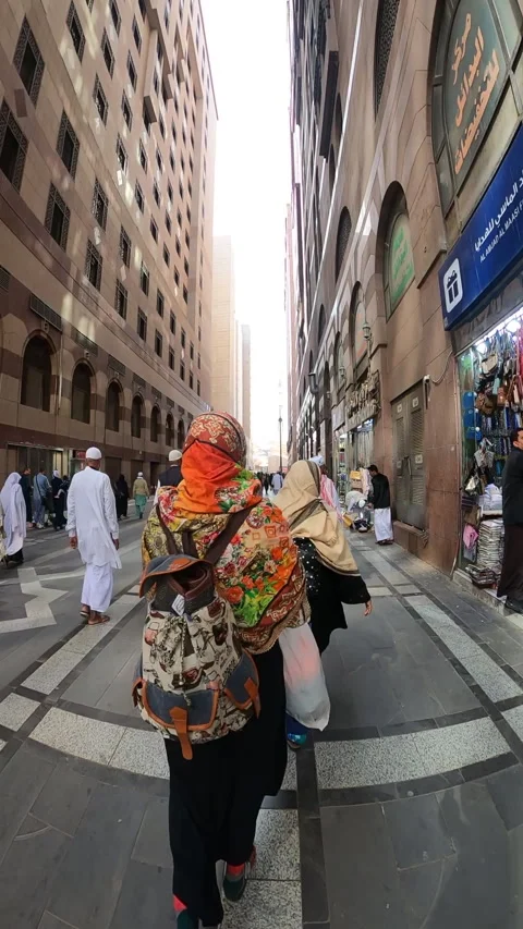 Walking Pilgrims on Paved Street Between Tall Buildings in Medina Vídeo Stock 322051020