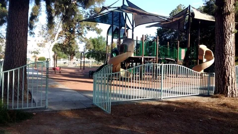 Walking into a playground gated area. Video stock 99615082