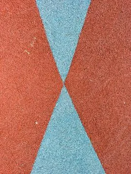 Walking on a playground surface covered in red and blue material. The surface Stock Photos