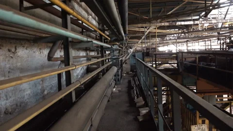 Walking POV Along Catwalk Inside Old Industrial Plant With Pipes And Crane Stock Footage 340489026