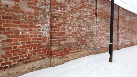 Walking in the red brick wall in winter Stock Footage 146375010
