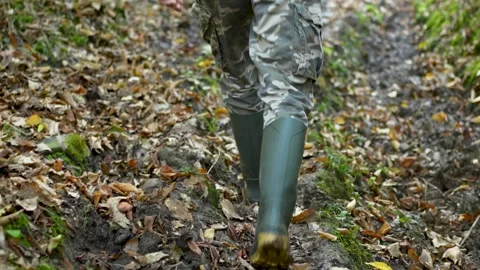 Walking in rubber boots on muddy forest trail in autumn. Stock Footage 320421265