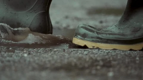 Walking in rubber boots through puddles on a rainy day. splashes of water Stock Footage 313283462