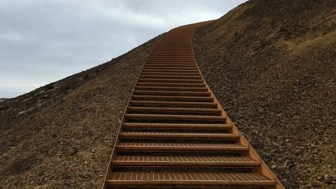 Walking a rusty metal staircase to the top of a mountain Stock Footage 88799516