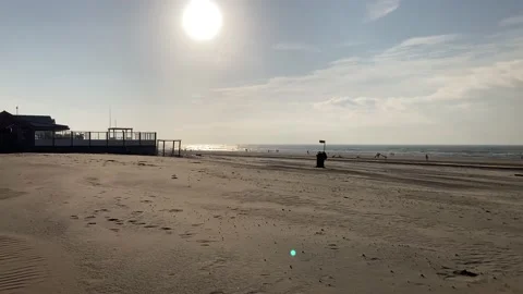 Walking on a sand at the beach with small wind spreading the golden dus Stock Footage