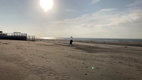 Walking on a sand at the beach with small wind spreading the golden dust Video stock 143811452