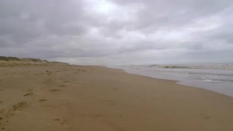 Walking in the sand of an empty lonely beach aside the sea waves Stock Footage 133729013