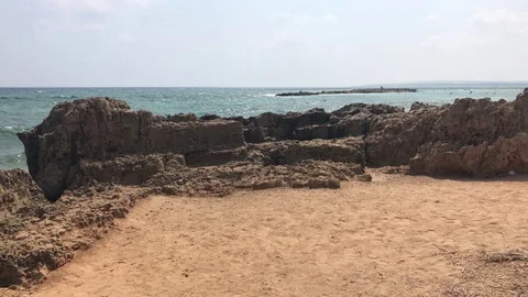 Walking on sand to the rocky side of beach Video stock 95035596